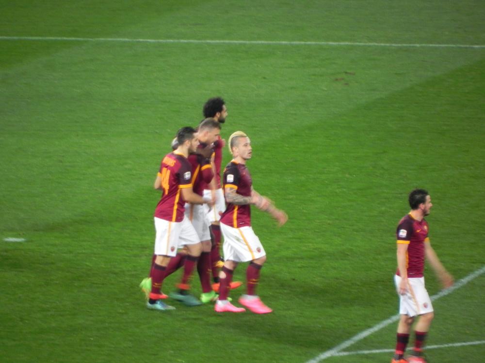 Dzeko abbracciato dai compagni dopo il gol